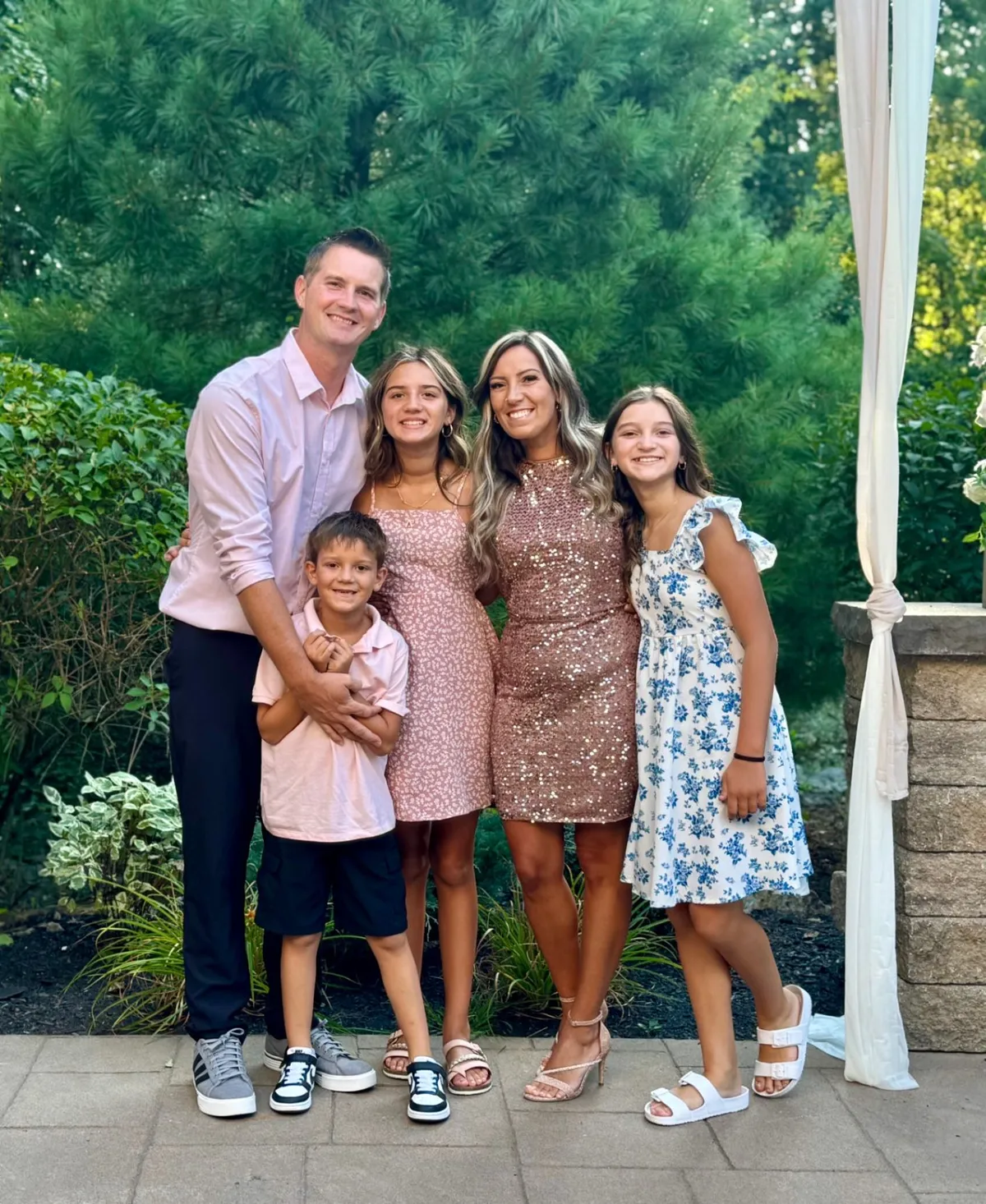 Joshua Parsley pictured with his family, including two women, a girl, and a young boy, outdoors among trees